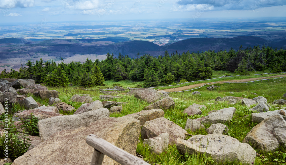 Granite blocks on the Brocken plateau in front of a spruce plantation with a view of the flat Vorharz in the distance to the horizon