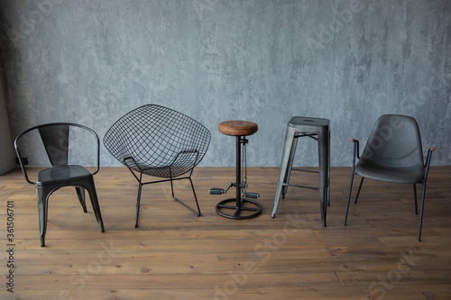 black designer chairs on a wooden floor against a botanical gray wall 