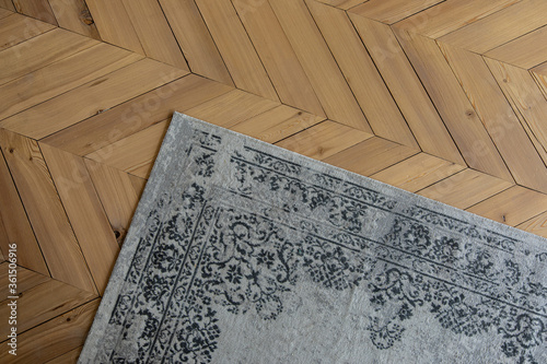 gray patterned carpet lies on a wooden floor