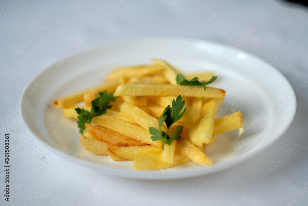 sliced fried potatoes with parsley on a white plate. Food photography. sliced fried potatoes with parsley on a white plate. Food photography.