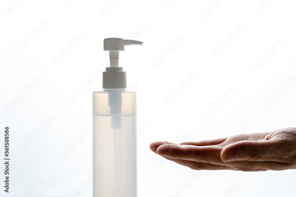 Hand silhouette waiting for disinfectant gel with illuminated ba Hand silhouette waiting for disinfectant gel with illuminated ba