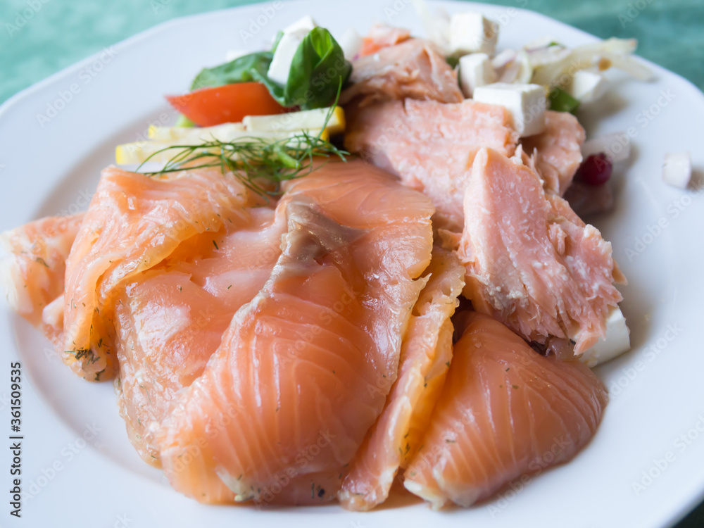 Delicious salmon with vegetables served on white plate