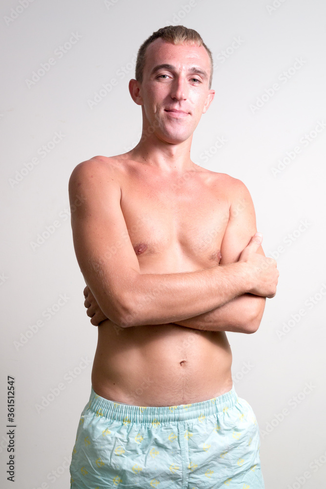 Fototapeta premium Portrait of happy blond man smiling with arms crossed shirtless