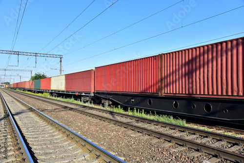 Cargo Containers Transportation On Freight Train By Railway. Intermodal Container On Train Car. Rail Freight Shipping Logistics. Import - export goods from Сhina