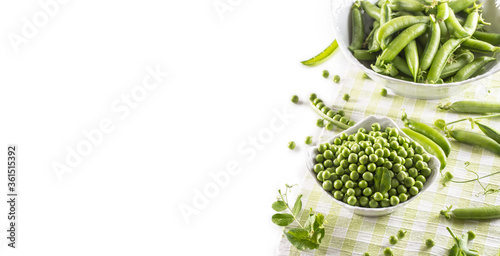 Green raw peas and pods in pocelain bow isolated on white background photo