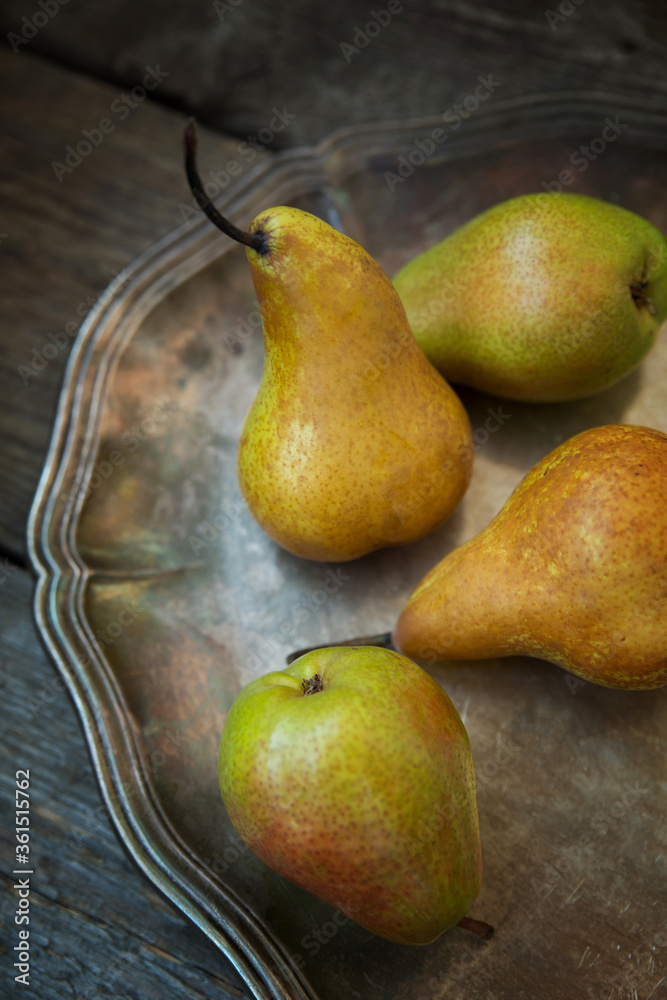 Pears on a tray and an old wooden background.