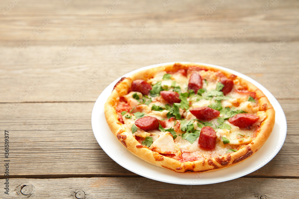 Tasty Italian pizza with sausage on grey wooden table with copy space