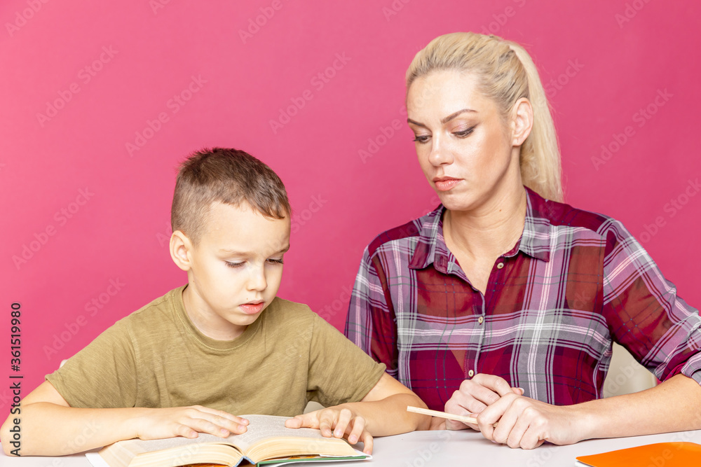 Mother and child som doing homework writing and reading at home. Home education at quarantine time. Mother and child som doing homework writing and reading at home. Home education at quarantine time.