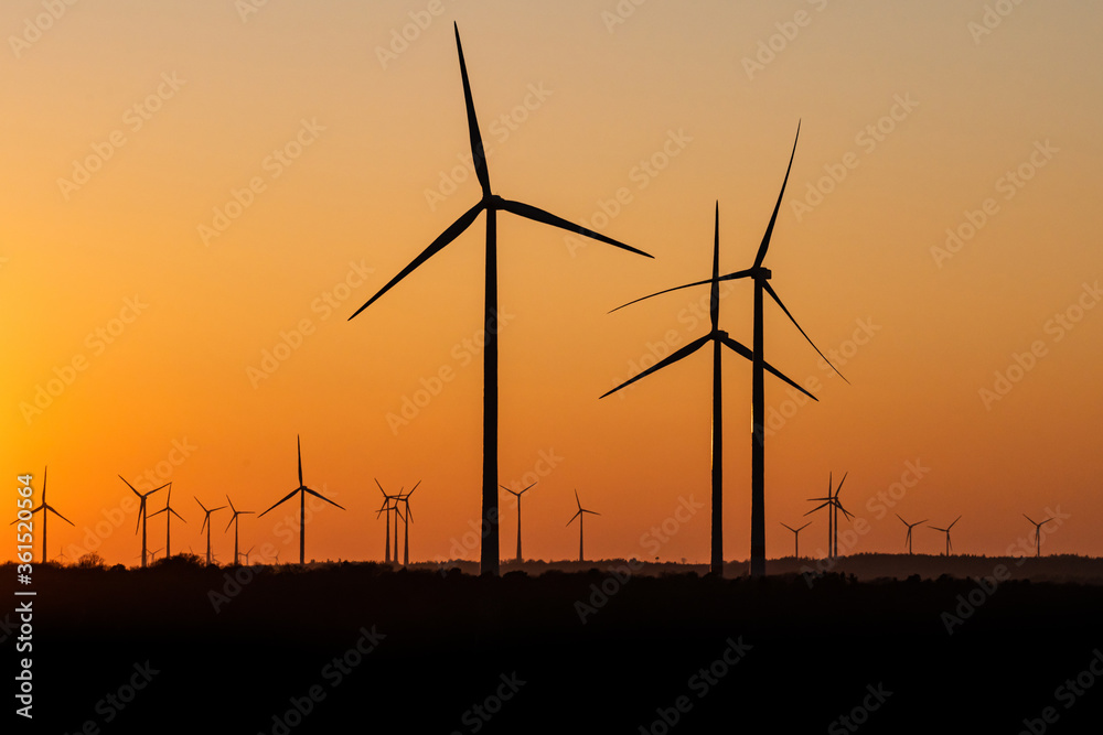 Black Silhouette of windturbines energy generator on amazing sunset at a wind farm in germany Black Silhouette of windturbines energy generator on amazing sunset at a wind farm in germany