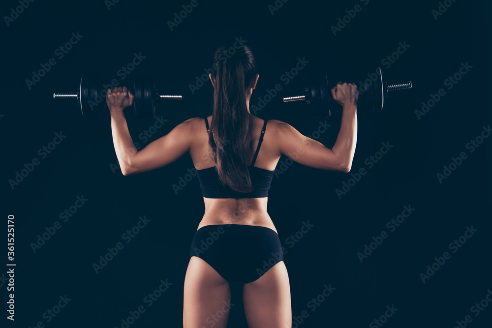 Back rear photo of anonymous lady raise barbells want be sportive hair brunette hairstyle ponytails isolated over black background