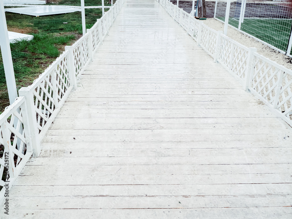 Walking trail in the form of a white wooden bridge in the open air