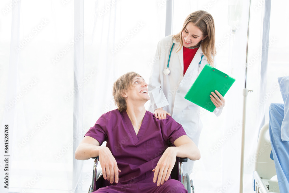 Patient in a wheelchair and Female beautiful wearing a doctor uniform standing on the side. Patient in a wheelchair and Female beautiful wearing a doctor uniform standing on the side.