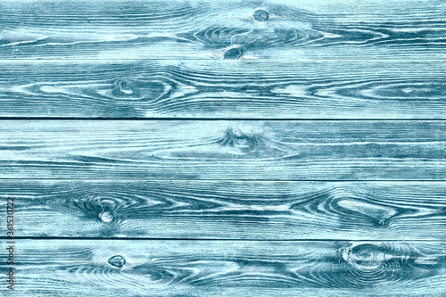 Background with unevenly applied paint, old and worn with a well-defined wood texture. Interesting texture of the wooden background. Background with a pronounced wood texture, colored green