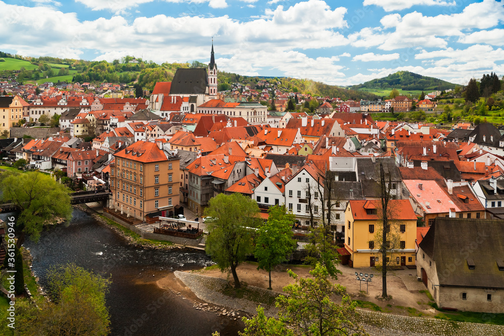 Cesky Krumlov with Vltava river seen from above with red roofs and St. Vitus church on a beautiful day