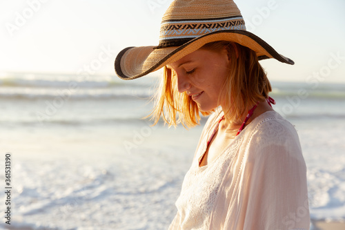 Woman wearing hat smiling on the beach