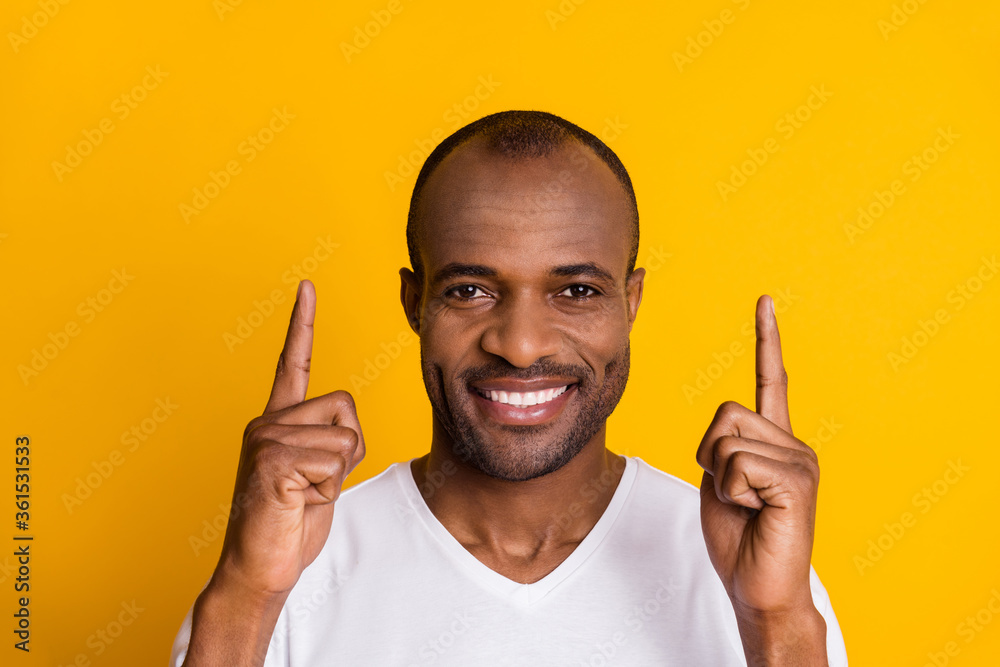 Positive cheerful afro american guy point index finger up copy space indicate advert promo recommend suggest select wear good look style outfit isolated bright shine color background