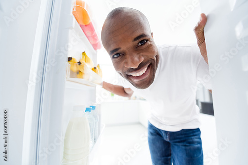 Close-up portrait of his he nice attractive cheerful cheery healthy guy looking in fridge finding fresh meal dish vitamin salad daily everyday health regime light white interior house kitchen indoors