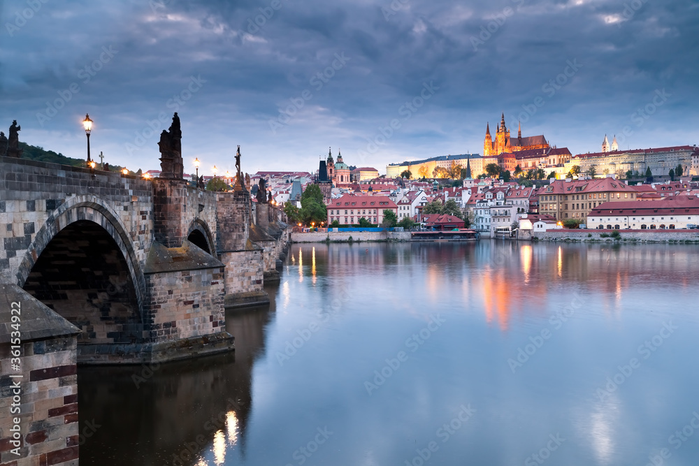 Side view of Charles bridge and illuminated Prague castle just after sunset