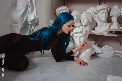 Beautiful young girl with blue hair in the sculptor's studio.