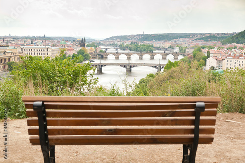 Beautiful view of the bridges of Prague over Vltava river with an empty bench ready for people in the blurred foreground