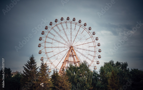 Ferris wheel with closed booths against the sky. Amusement Park on a summer day.