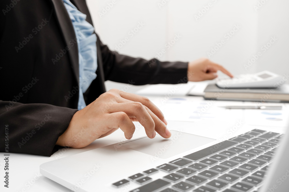 The hands of a male businesswoman use the calculator are analyzing and calculating the annual income and expenses in a financial graph that shows results To summarize balances overall in office The hands of a male businesswoman use the calculator are analyzing and calculating the annual income and expenses in a financial graph that shows results To summarize balances overall in office