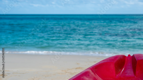 Background of beautiful summer holiday vacation on white clean sand beach clear sea water quite wave with red Kayak boat for fun active activity 