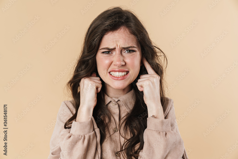 Image of unhappy brunette nice woman plugging her ears Image of unhappy brunette nice woman plugging her ears