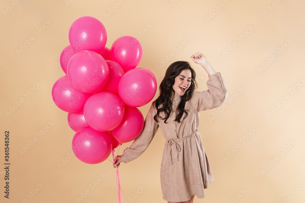 Image of excited cute woman laughing and dancing with pink balloons Image of excited cute woman laughing and dancing with pink balloons