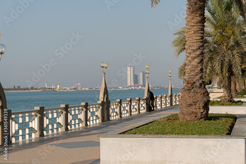 Embankment with water, palms and fisherman with a bicycle