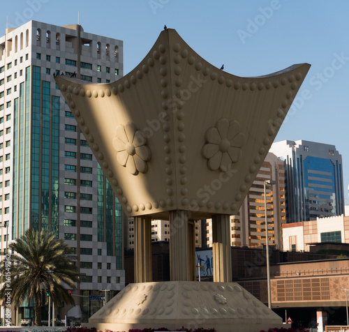 Abu Dhabi/United Arab Emirates - August 2019: Al Ittihad Square with a traditional incense burner on the foreground and buildings with palm on the background