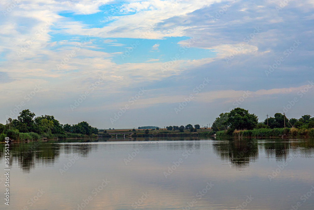 Obraz premium Sunny day on a calm river in summer