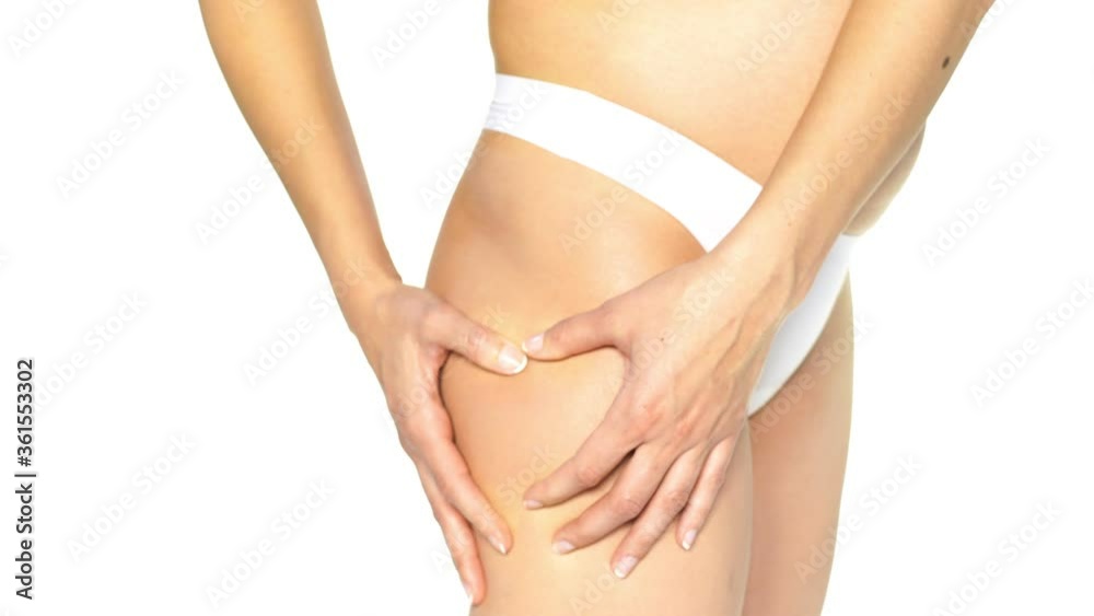 a young woman in early pregnancy pinching the cellulite on her hips on a white background a young woman in early pregnancy pinching the cellulite on her hips on a white background