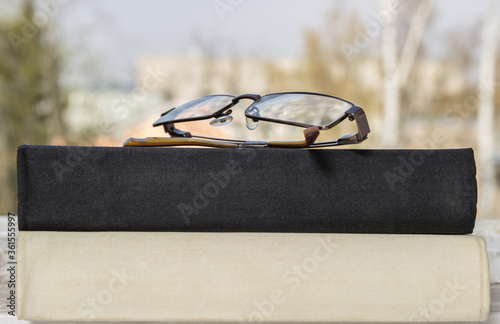 Black and white books and glasses on the windowsill. Reading books