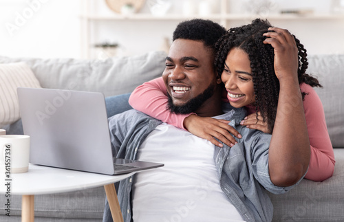 Caring Black Woman Supporting Boyfriend While He Working On Laptop At Home