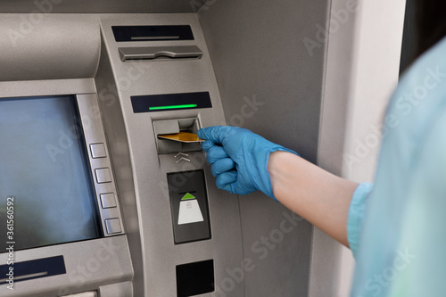 Wallpaper Mural Female hand in protective medical glove putting credit card into ATM machine Torontodigital.ca