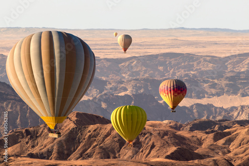 Colorful hot air balloons flying over the moon valley mountain. Africa.