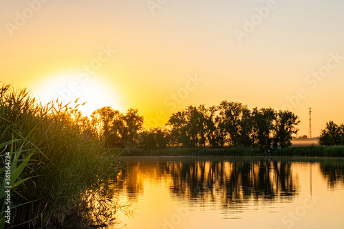 Orange sunset on a calm river in summer