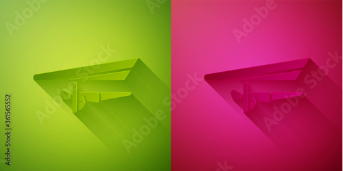 Paper cut Hang glider icon isolated on green and pink background. Extreme sport. Paper art style. Vector Illustration.