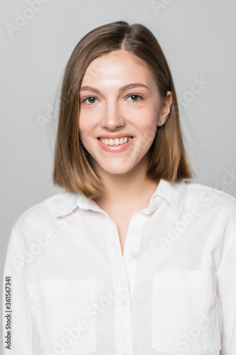 Smiling young business woman against white background.