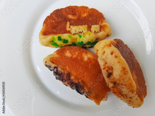 Pukis, is an Indonesian traditional pancake, with various toppings. On white plate. Isolated in white background. photo