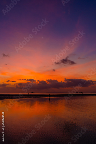 Burning bright sky during sunset on a tropical beach. Sunset during the exodus, the strength of people walking on water