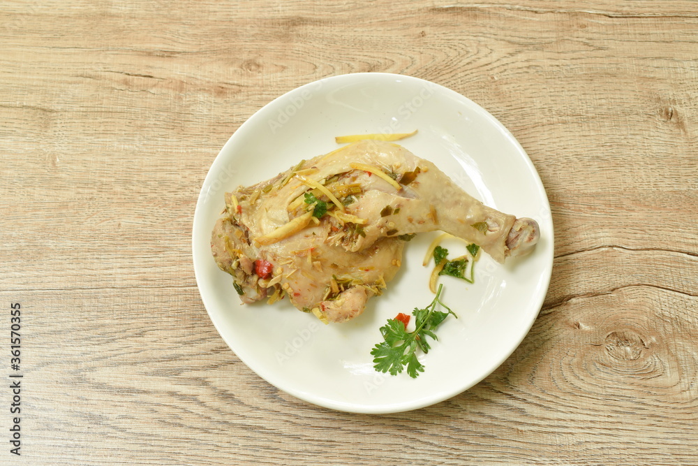 steamed spicy chicken thigh and leg with slice ginger on palte