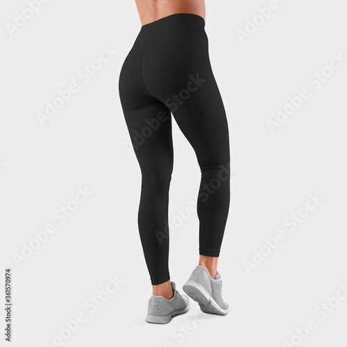 Mockup of black trousers for sports and training on the slim legs of a girl, for presentation of design, logo, rear view.