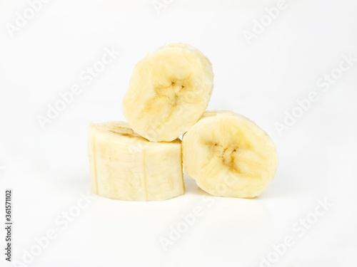 Banana slices on a white background. Peeled and chopped ripe banana. Yellow tropical fruit isolated on white