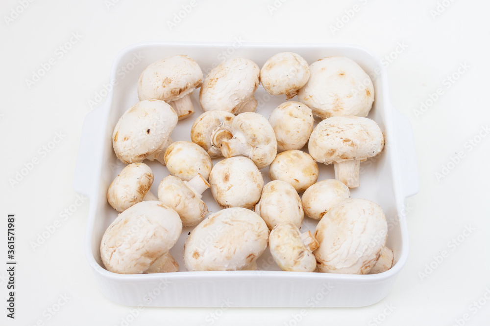 Fresh champignons in a white ceramic baking dish Fresh champignons in a white ceramic baking dish