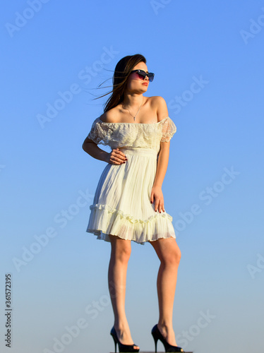 Towards summer. Freedom and Harmony. Female psychology. Beautiful woman on sunny day blue sky. Summer fashion. Girl in sunglasses copy space. Wind of change. Fancy model in tender summer dress