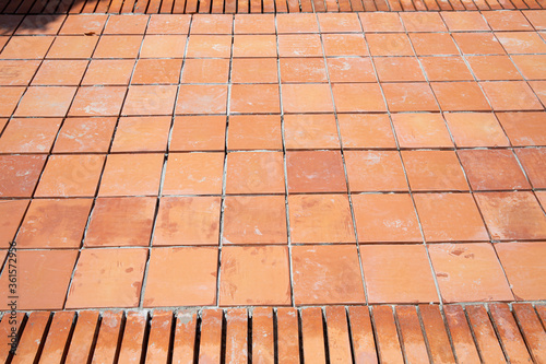 The pavement constructed from brown tiles and bricks