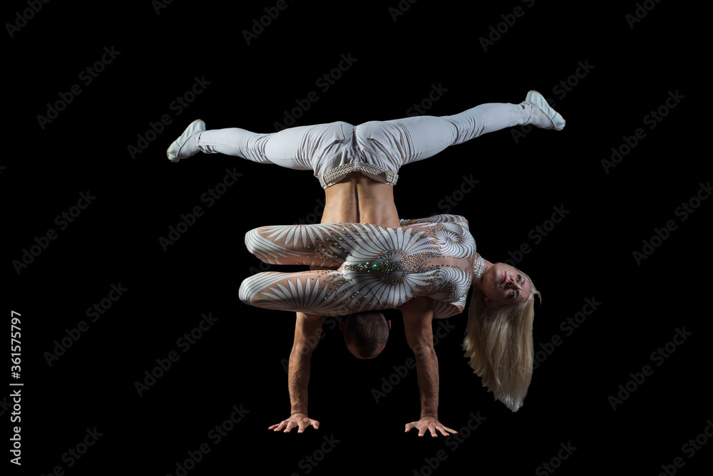 portrait of acrobats guy with a girl in white isolated on a black ...