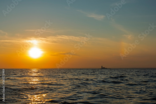 Sunset over the waters of the Bay with a sun halo and the silhouette of the lighthouse © unww